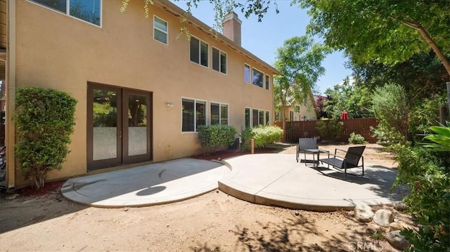 25030 Crimson Lasso Dr, Wildomar, CA 92595 - back of property with a patio area, stucco siding, french doors, and a chimney