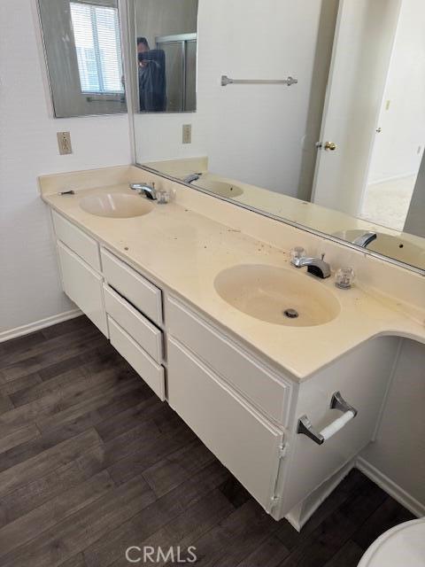 37733 Harvey St, Palmdale, CA 93550 - bathroom with wood finished floors, double vanity, baseboards, and a shower with door