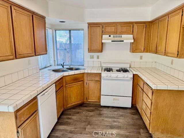 37733 Harvey St, Palmdale, CA 93550 - kitchen featuring under cabinet range hood, white appliances, a sink, dark wood-style floors, and brown cabinetry