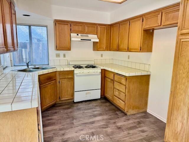 37733 Harvey St, Palmdale, CA 93550 - kitchen featuring white range with gas cooktop, a sink, tile counters, under cabinet range hood, and dark wood-style floors