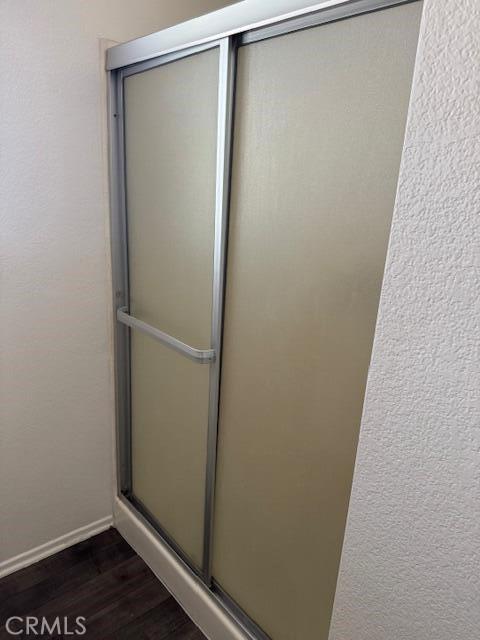 37733 Harvey St, Palmdale, CA 93550 - bathroom with wood finished floors, a stall shower, and baseboards