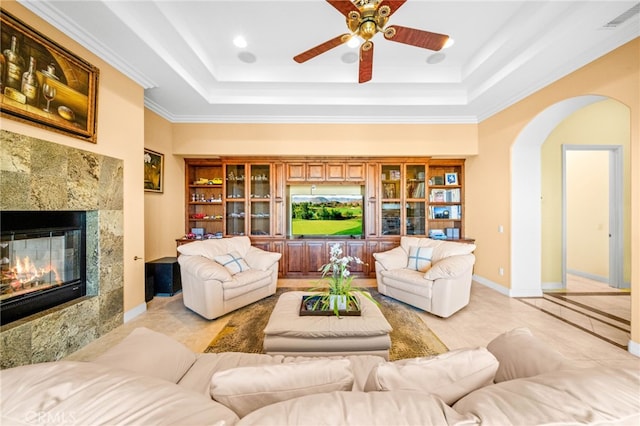 37626 Via Majorca, Murrieta, CA 92562 - living area featuring a ceiling fan, arched walkways, a tray ceiling, a fireplace, and crown molding