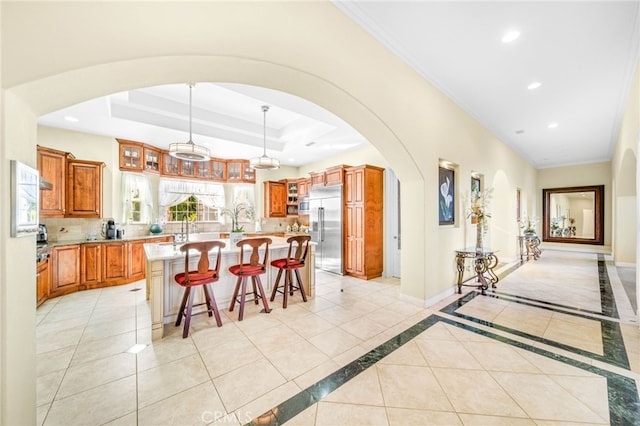37626 Via Majorca, Murrieta, CA 92562 - kitchen with built in refrigerator, decorative backsplash, a breakfast bar, brown cabinets, and an island with sink