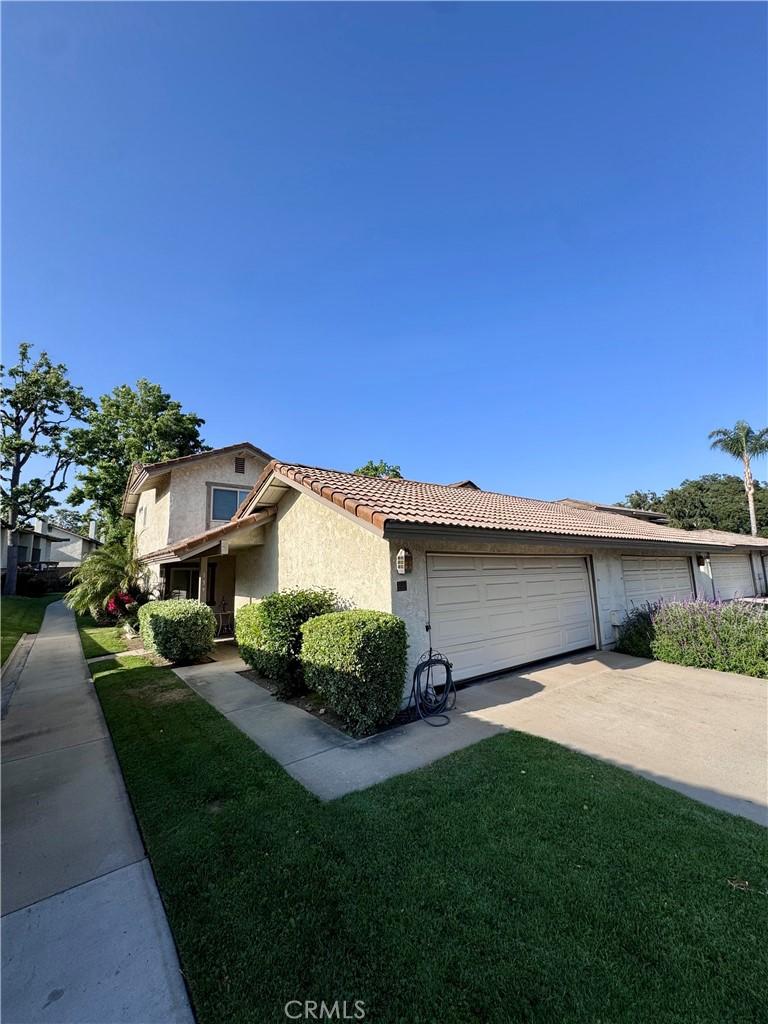 137 Oak Forest Cir, Glendora, CA 91741 - view of front of home with a tiled roof, stucco siding, driveway, a front yard, and an attached garage