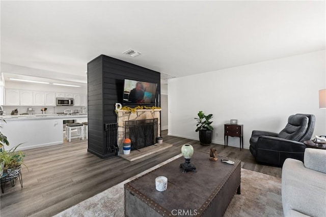 1459 Clock Ave, Redlands, CA 92374 - living room featuring light wood finished floors, a stone fireplace, and baseboards