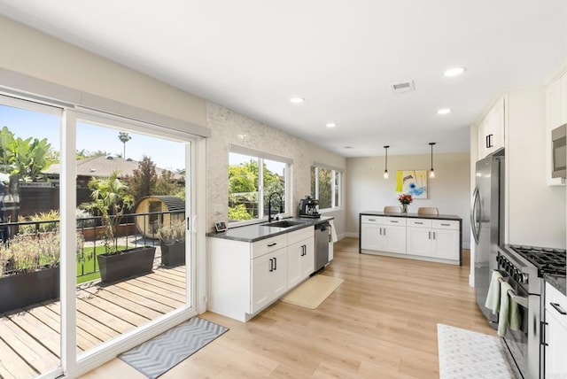 6153 Baltimore Dr, La Mesa, CA 91942 - kitchen with stainless steel appliances, dark countertops, a sink, light wood finished floors, and recessed lighting