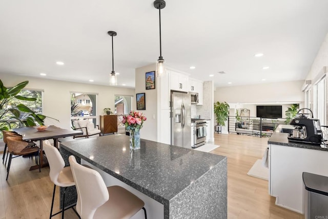 6153 Baltimore Dr, La Mesa, CA 91942 - kitchen with appliances with stainless steel finishes, open floor plan, white cabinets, light wood finished floors, and a kitchen island