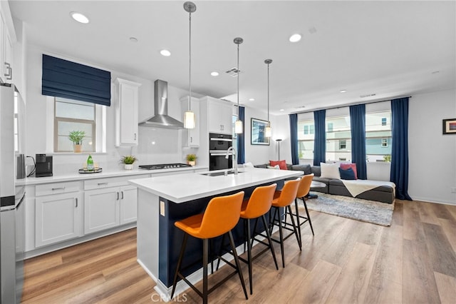 181 Moonflower Rd, Rancho Mission Viejo, CA 92694 - kitchen with wall chimney exhaust hood, gas cooktop, a sink, a center island with sink, and open floor plan
