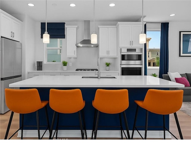181 Moonflower Rd, Rancho Mission Viejo, CA 92694 - kitchen with wall chimney range hood, stainless steel appliances, light countertops, a sink, and recessed lighting