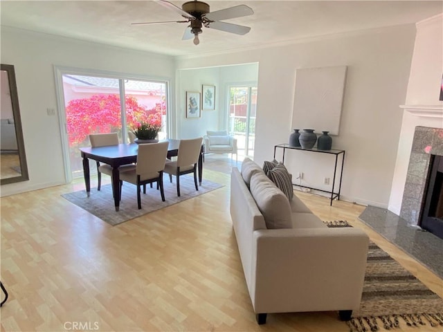 619 Center St, El Segundo, CA 90245 - dining room featuring a high end fireplace, ceiling fan, light wood-style flooring, healthy amount of natural light, and ornamental molding