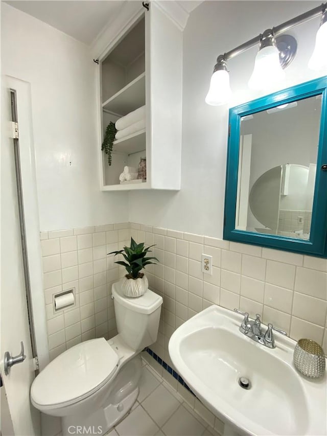 619 Center St, El Segundo, CA 90245 - bathroom featuring a sink, toilet, tile walls, a wainscoted wall, and tile patterned floors