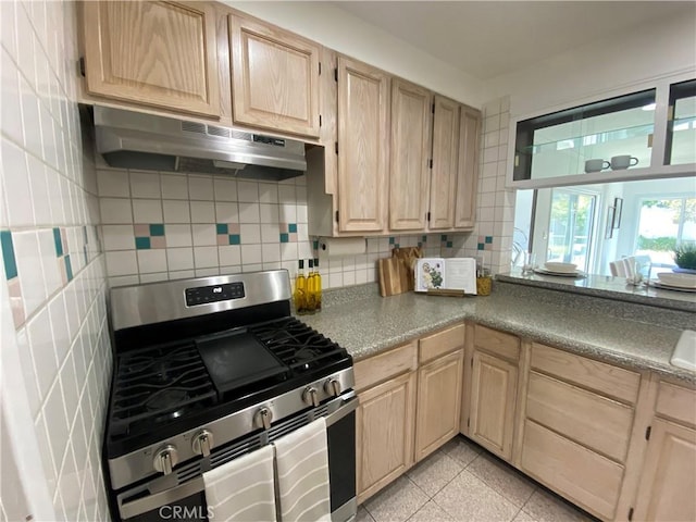 619 Center St, El Segundo, CA 90245 - kitchen with gas range, under cabinet range hood, light brown cabinetry, and tasteful backsplash