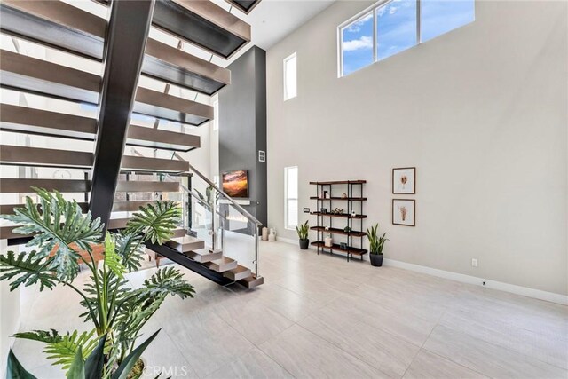 20537 W Overlook Ct, Porter Ranch, CA 91326 - tiled living area with stairs, a high ceiling, and baseboards