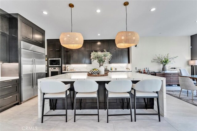 20537 W Overlook Ct, Porter Ranch, CA 91326 - kitchen featuring built in appliances, decorative backsplash, recessed lighting, light stone counters, and pendant lighting