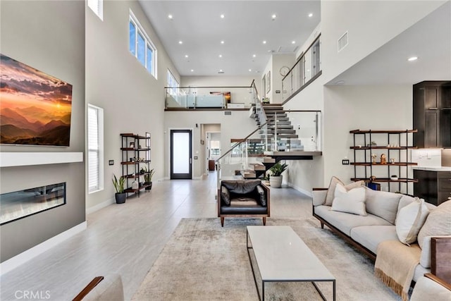 20537 W Overlook Ct, Porter Ranch, CA 91326 - living area featuring stairway, a high ceiling, recessed lighting, and a glass covered fireplace