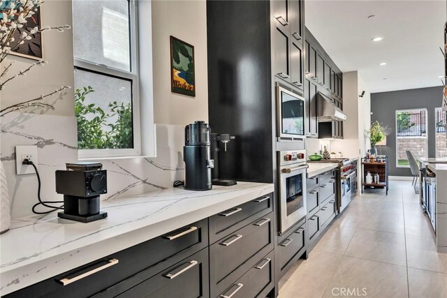 20537 W Overlook Ct, Porter Ranch, CA 91326 - kitchen with appliances with stainless steel finishes, recessed lighting, light stone counters, under cabinet range hood, and light tile patterned flooring