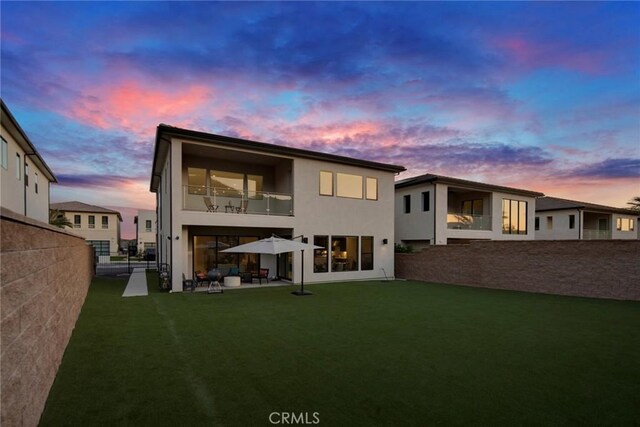 20537 W Overlook Ct, Porter Ranch, CA 91326 - back of property at dusk with a balcony, stucco siding, and a patio area