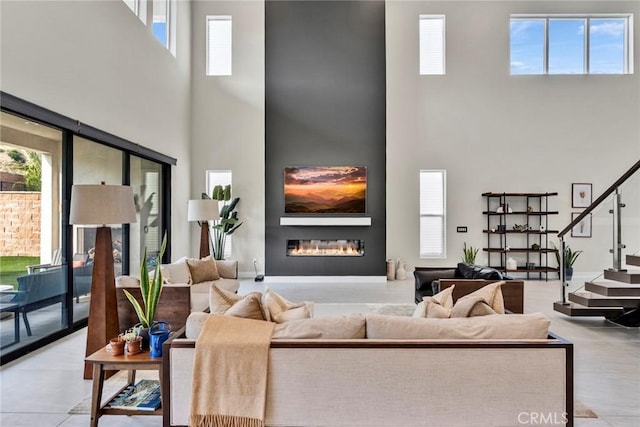 20537 W Overlook Ct, Porter Ranch, CA 91326 - living room with a towering ceiling, a glass covered fireplace, healthy amount of natural light, and stairs