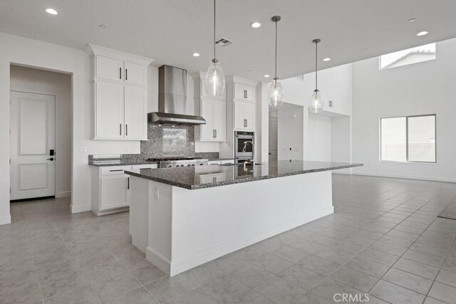 17744 Mcdowell Valley Dr, Riverside, CA 92503 - kitchen featuring wall chimney range hood, backsplash, a kitchen island with sink, light tile patterned floors, and recessed lighting