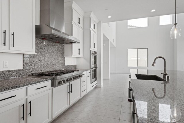 17744 Mcdowell Valley Dr, Riverside, CA 92503 - kitchen featuring wall chimney range hood, a sink, appliances with stainless steel finishes, tasteful backsplash, and dark stone counters