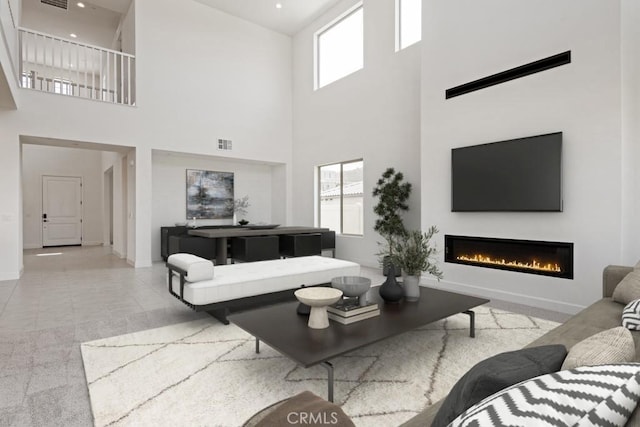 17744 Mcdowell Valley Dr, Riverside, CA 92503 - living room featuring a glass covered fireplace, plenty of natural light, a high ceiling, and baseboards