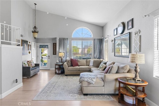 1337 Lloyd Pl, Lompoc, CA 93436 - living room with wood finished floors, baseboards, and high vaulted ceiling