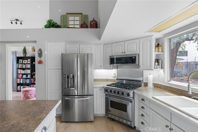 1337 Lloyd Pl, Lompoc, CA 93436 - kitchen featuring stainless steel appliances, a sink, white cabinetry, light wood finished floors, and open shelves