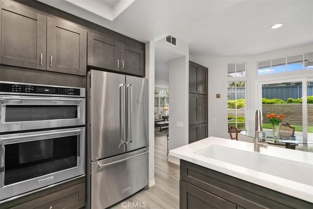 3510 Lilac Ave Unit 13, Corona Del Mar, CA 92625 - kitchen with appliances with stainless steel finishes, light countertops, light wood-style floors, dark brown cabinetry, and recessed lighting