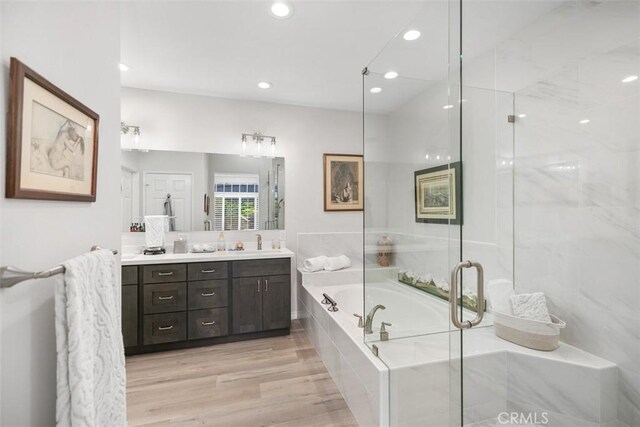 3510 Lilac Ave Unit 13, Corona Del Mar, CA 92625 - bathroom featuring a garden tub, double vanity, a stall shower, recessed lighting, and wood finished floors