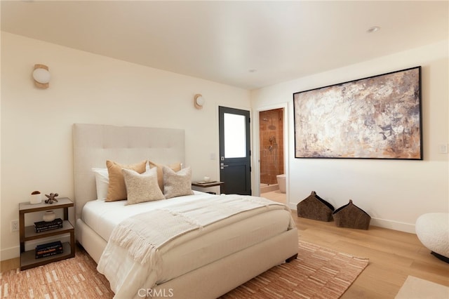 3554 S Sycamore Ave, Los Angeles, CA 90016 - bedroom with wood finished floors, baseboards, and connected bathroom