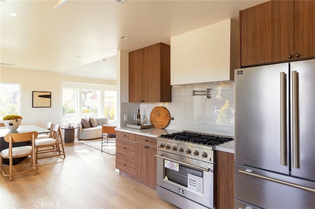 3554 S Sycamore Ave, Los Angeles, CA 90016 - kitchen with appliances with stainless steel finishes, light countertops, brown cabinets, tasteful backsplash, and plenty of natural light