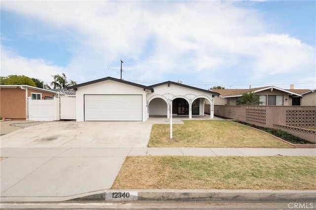 12340 Dune St, Norwalk, CA 90650 - ranch-style house featuring a garage, concrete driveway, stucco siding, and a porch