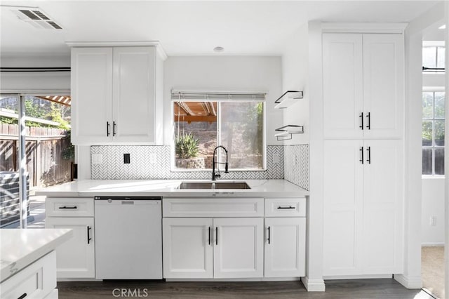 16207 Trailwinds Dr, Fontana, CA 92337 - kitchen with dishwasher, decorative backsplash, white cabinetry, and dark wood-type flooring
