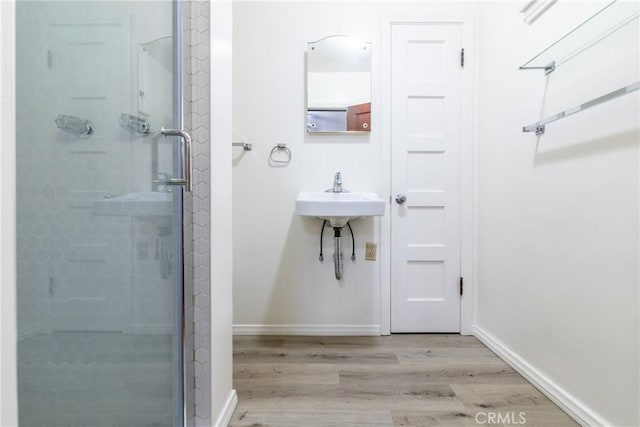 4899 Glenwood Dr, Riverside, CA 92501 - bathroom with a stall shower, wood finished floors, and baseboards