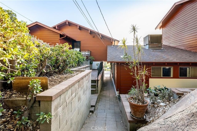 4899 Glenwood Dr, Riverside, CA 92501 - view of side of property with central AC and roof with shingles