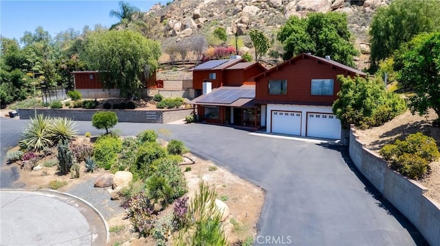 4899 Glenwood Dr, Riverside, CA 92501 - view of front of property featuring a garage, roof mounted solar panels, and asphalt driveway