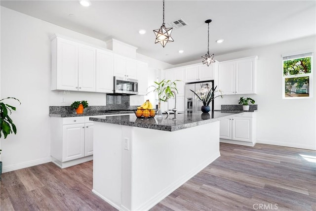 8675 Bay Laurel St, Chino, CA 91708 - kitchen featuring stainless steel appliances, light wood finished floors, white cabinetry, recessed lighting, and a kitchen island