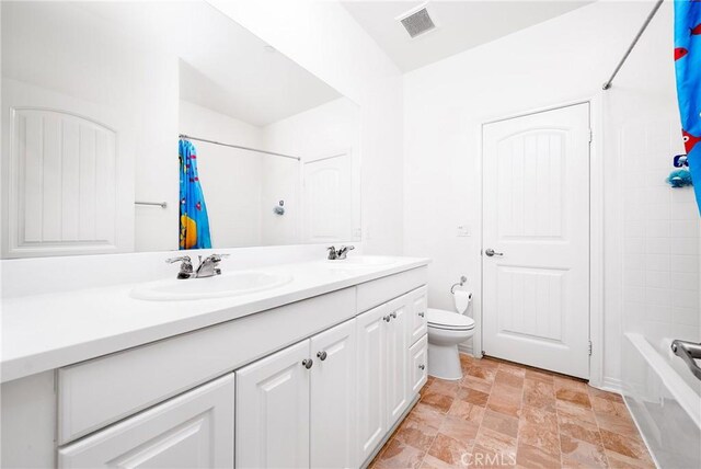 8675 Bay Laurel St, Chino, CA 91708 - bathroom featuring double vanity, stone finish flooring, toilet, and shower / bath combination with curtain