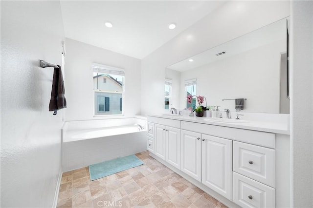 8675 Bay Laurel St, Chino, CA 91708 - full bathroom featuring double vanity, plenty of natural light, stone finish floors, a bath, and recessed lighting