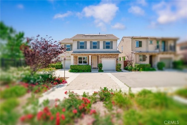 8675 Bay Laurel St, Chino, CA 91708 - traditional home with stucco siding, driveway, an attached garage, roof mounted solar panels, and stone siding