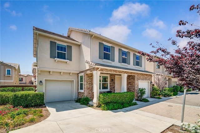8675 Bay Laurel St, Chino, CA 91708 - view of front of home featuring a garage, stucco siding, concrete driveway, and brick siding