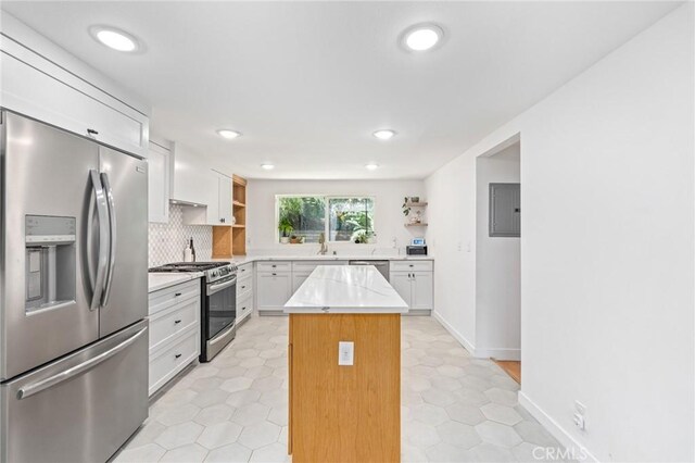 4501 Don Miguel Dr, Los Angeles, CA 90008 - kitchen with appliances with stainless steel finishes, open shelves, white cabinetry, a kitchen island, and backsplash