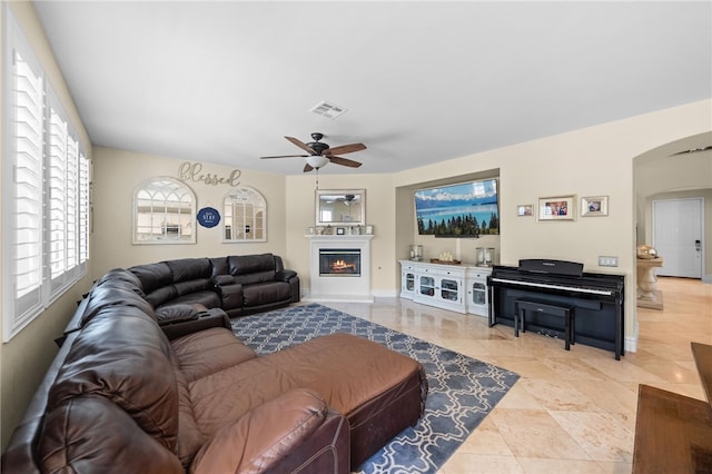 34032 Temecula Creek Rd, Temecula, CA 92592 - living room with arched walkways, ceiling fan, a glass covered fireplace, and healthy amount of natural light