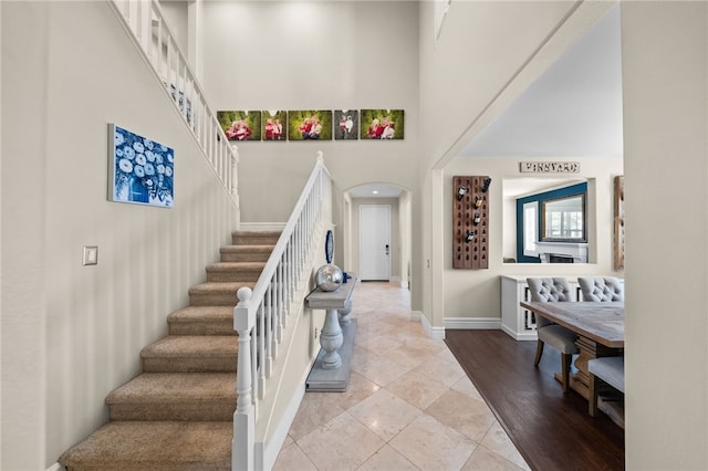 34032 Temecula Creek Rd, Temecula, CA 92592 - foyer entrance featuring stairway, a high ceiling, arched walkways, and light tile patterned flooring