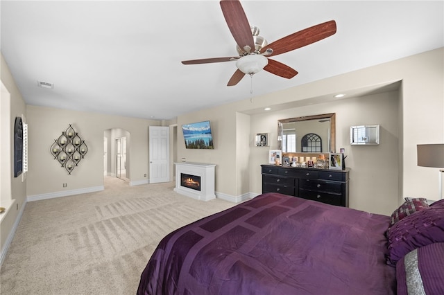 34032 Temecula Creek Rd, Temecula, CA 92592 - bedroom featuring arched walkways, carpet, a lit fireplace, and a ceiling fan