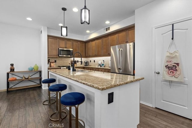 1855 Orizaba Unit 103, Signal Hill, CA 90755 - kitchen with stainless steel appliances, dark wood-type flooring, decorative backsplash, light stone counters, and an island with sink