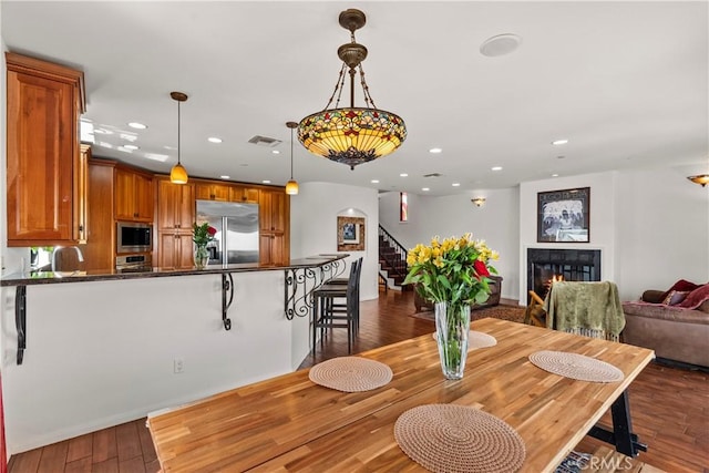 633 Sunnyhill Dr, Los Angeles, CA 90065 - dining space with stairway, recessed lighting, dark wood-style floors, and a lit fireplace