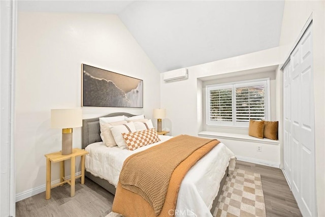 407 E Duarte Rd Unit D, Arcadia, CA 91006 - bedroom featuring a wall mounted air conditioner, wood finished floors, lofted ceiling, baseboards, and a closet