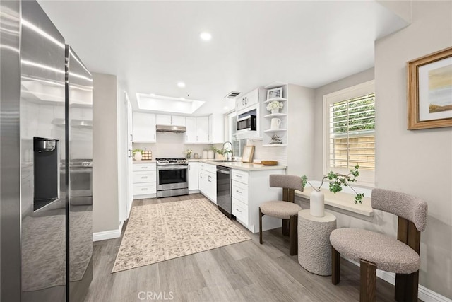 407 E Duarte Rd Unit D, Arcadia, CA 91006 - kitchen with appliances with stainless steel finishes, wood finished floors, under cabinet range hood, light countertops, and white cabinetry