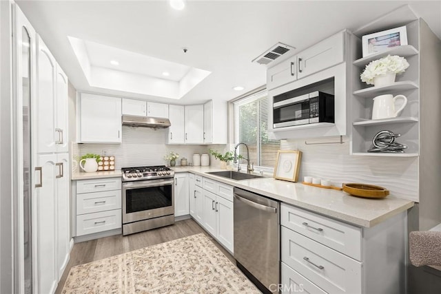 407 E Duarte Rd Unit D, Arcadia, CA 91006 - kitchen featuring stainless steel appliances, a sink, under cabinet range hood, white cabinetry, and light wood-style flooring